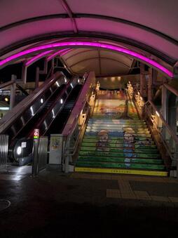 狭山市駅西口エレベーターのライトアップ写真です。ピンクリボン（乳がん）月間である10月の1か月間、西口エスカレーターがピンク色に点灯します。