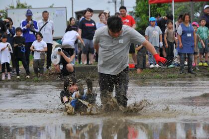 子どもをソリに乗せて引っ張るお父さん